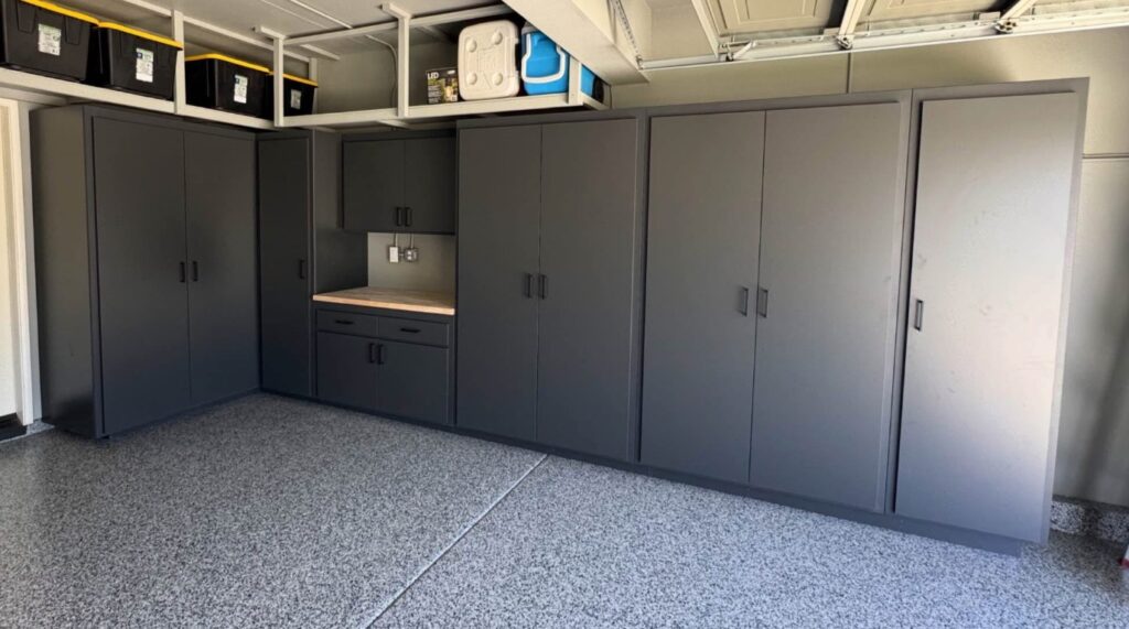 Custom garage storage cabinets with overhead shelves and workbench in Houston home